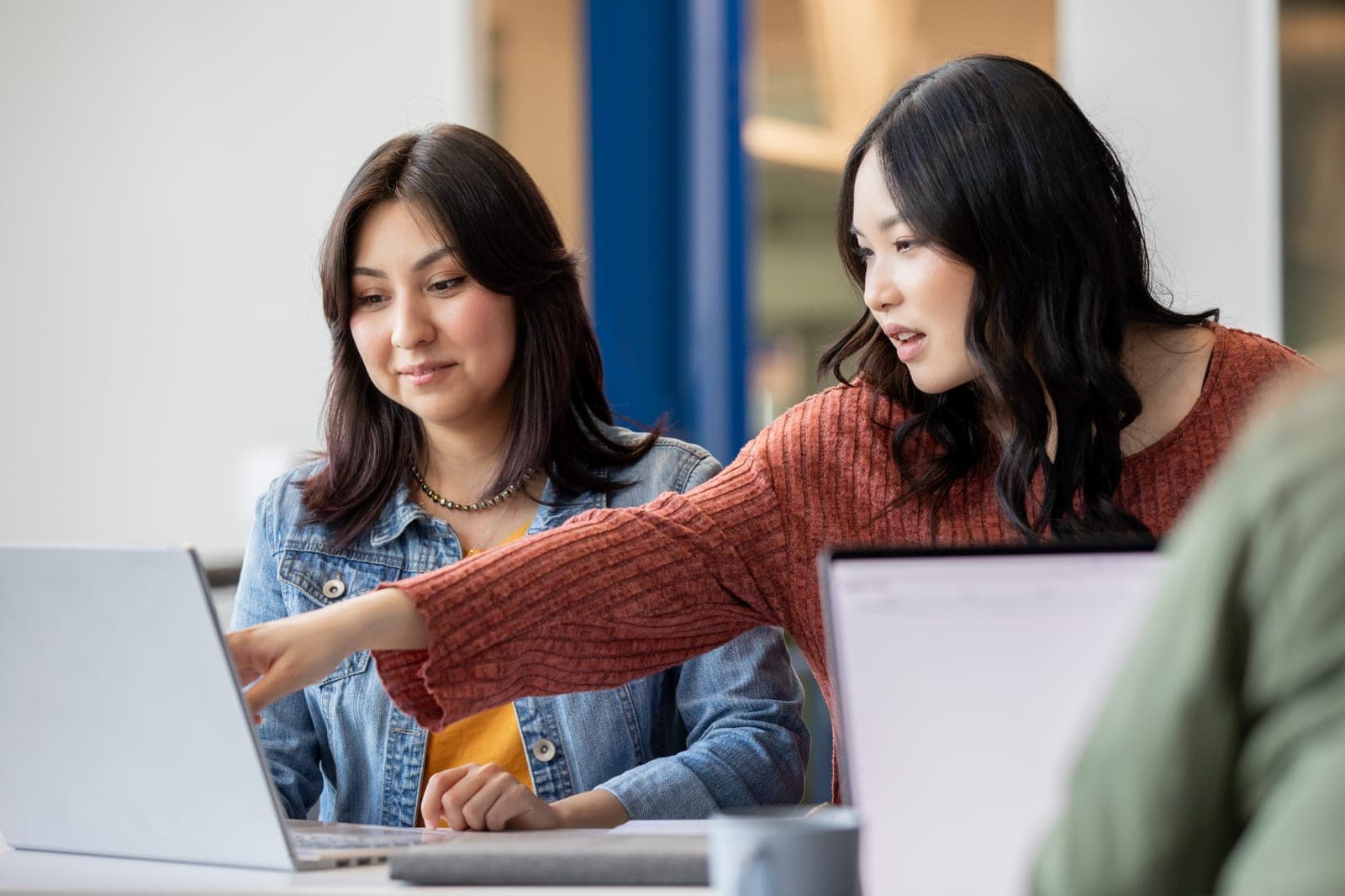 Two behavior analysts reviewing training materials together on a laptop